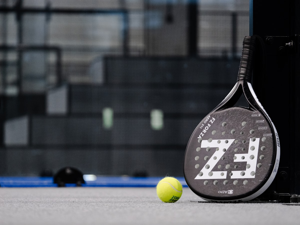 Raquette de padel et balle sur le terrain
